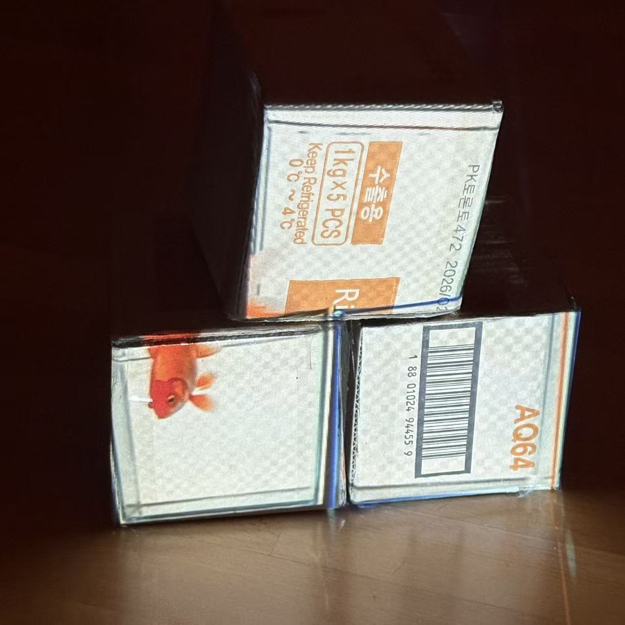 After finding the right animated image and adjusting its dimensions, it appears as though a goldfish is swimming between three cardboard boxes.